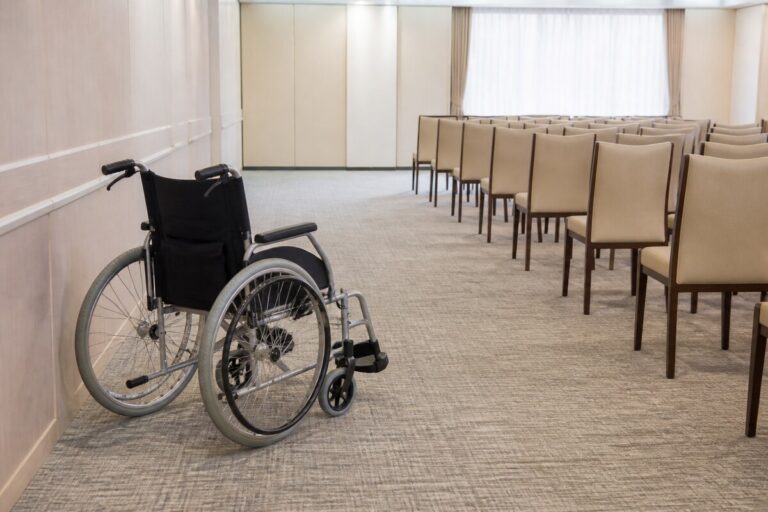 車いすで葬儀に参列するため会場の通路と座席を確認するイメージ画像